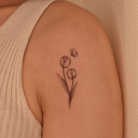 Fine line tulip tattoo on the shoulder. Metamorphosis Tattoo Small, Rob Cage Tattoos Women, 3 Tulips Tattoo, Amsterdam Tattoo Ideas Small, Tulip Tatoos Ideas, Tulip And Butterfly Tattoo, Simple Fineline Tattoos, Dainty Tulip Tattoo, Tattoo Ideas Tulip