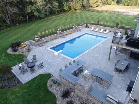 Check out our extensive outdoor entertainment space. Here is what we did:

- Installed a new underground pool
- Added an outdoor gas firepit
- Built a new outdoor kitchen with pizza oven, grill, and island
- Created multiple large paver patio areas
- Added paver walls and fire bowls around pool
- Installed new plants, edging, rock, and mulch Pool Patio Paver Ideas, Pool Fire Pit Outdoor Kitchen, Pool Patio Fire Pit, Backyard Oasis With Inground Pool, Outdoor Kitchen By Pool Ideas, Pool Deck With Fire Pit, Pavers By Pool, Built In Pool Ideas Backyards, Pool And Fire Pit Ideas Backyards