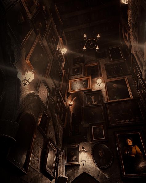 dark room with pictures covering the walls, pretty lanterns hanging on the walls. Hogwarts stairwell with moving portrait paintings Dark Academia Aesthetic Gray, Dark Academia Aesthetic Hogwarts, Magic Dark Academia, Fantasy Dark Academia Aesthetic, Haunted Boarding School Aesthetic, School Aethestic Dark, Dark Academia 70s Aesthetic, Harry Potter Aesthetic Dark Academia, Magical Dark Academia