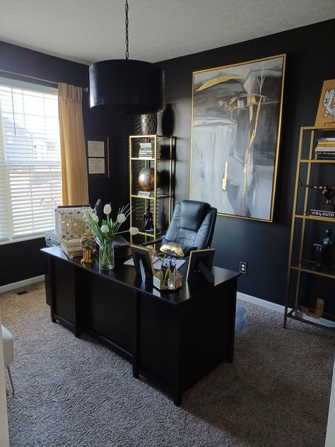 Home office painted in black, decorated with gold shelves, and gold accents. Black And Gold Home Office Ideas, Black Decor Office, Gold White Black Office, Male Desk Decor Office Ideas, His Office Decor, Grey Black Gold Dining Room, Black And White Office Decor Ideas, Boujee Home Office, Black Walls Office Design