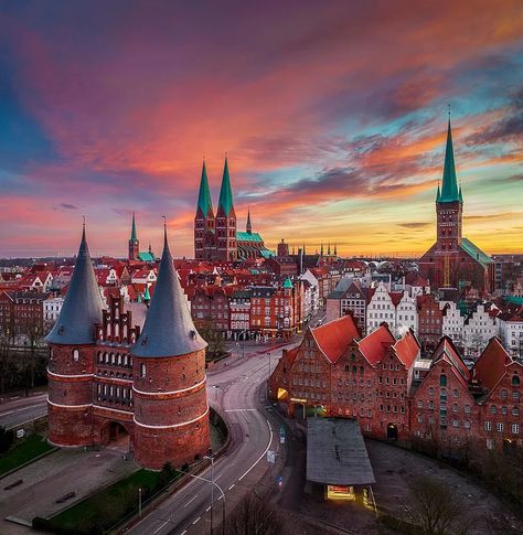 Colorful sunrise at the Holstentor in Lübeck, Germany Germany Landscape, Germany Travel Destinations, Colorful Sunrise, German Travel, Invisible Cities, Glass Print, Lviv, City Aesthetic, Beautiful Places To Travel