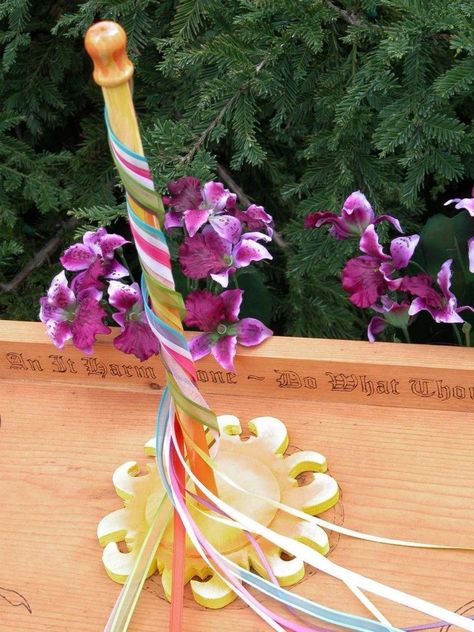 A tabletop Maypole!  You need:  1" thick dowel rod, 1 foot long. A wooden circle, 4" in diameter. Pieces of ribbon in various colors (red & white for the God and Goddess, any bright colors) 2 feet long, each. Use a hot glue gun to attach the dowel rod to the center of the wooden circle. Paint it if you like. Attach the center of each ribbon to the top of the dowel rod. Optional: add a small floral crown around the bottom, or add Sea Shells, Fairies, Beach Glass, Crystals, etc Mini Maypole, Beltane Crafts, May Pole, Solitary Witch, Crochet Machine, Wiccan Crafts, Embroidery Painting, Pagan Crafts, Sewing Crochet