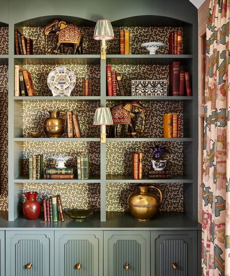 'We love to cover the backs of our bookcases in a small-scale wallpaper to make them pop and add interest: this is particularly effective if you don't have a huge collection of books as it doesn't matter if the bookcase is full or not,' explains @elizabethhaydesign. We always love to have some cute little library bookcase lights with shades which adds further detail and soft lighting in the evenings.' . Photography by @mkisiday . See more bookshelf styling tips at the link in bio. . #homesand... Wallpaper Lined Bookshelves, Painted Bookcase With Wallpaper, Black Bookshelf With Wallpaper Backing, Wallpaper In Bookcase, Library With Wallpaper, Wallpaper On Bookcase, Wallpaper Backed Bookcases, Bookcases With Wallpaper Backs, Wallpaper Behind Bookshelves