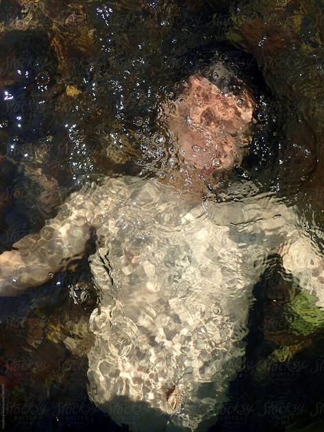 Bare upper body of the man, lying down into the water, blurred vision Man In Water Aesthetic, Someone Floating In Water, Person Lying In Water, Water Distortion Photography, Man Lying Down, Person In Water Drawing, Men In Water, Lying In Water, Sinking In Water