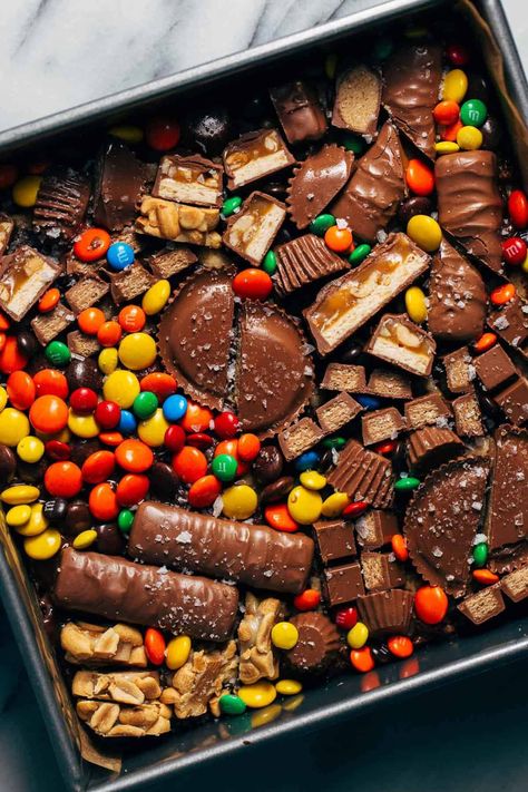 Not sure what to do with that bowl of leftover Halloween candy sitting on your counter? Put them to good use with these loaded halloween candy cookie bars! Soft and chewy bars are baked with chopped bits of candy inside and decorated with even more candy on top. #halloweencandy #cookiebars #candybars #candy #butternutbakery | butternutbakeryblog.com Cookies With Candy Bars In Them, Candy Cookie Bars, Chewy Bars, Butternut Bakery, Candy Bar Cookies, White Chocolate Brownies, Leftover Halloween Candy, Gooey Cookies, Candy Cookie