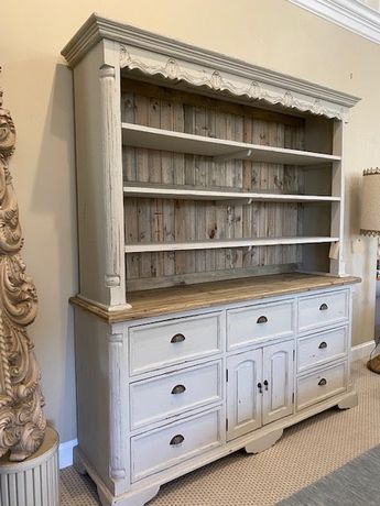 Farmhouse Buffet and Hutch in a painted greyed White distressed finish with natural finished mahogany wood accents. A great Farmhouse piece with tons of storage. Antique metal hardware. All wood construction. Cabinet ships in 2 pieces - Base and Top. The hutch is crafted using Authentic Reclaimed New Zealand Pine. The finish is natural and appropriate for the period and the style of this hutch. It is hand made out of solid wood, and Bench Made meaning made one piece at a time representing the cr Buffet Hutch Makeover, Painted Buffet Ideas, Modern Farmhouse Hutch, White Distressed Cabinets, Refurbished Hutch, Painted China Hutch, Driftwood Dining Table, Country Hutch, Rustic Hutch