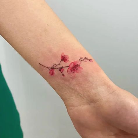 Simple Watercolor Cherry Blossom Flower Wrist Tattoo Idea & Design on Woman Wrist Simple Cherry Blossom Wrist Tattoo Done At Cherry Wrist Tattoo, Cherry Blossom Tattoo Simple, Simple Cherry Blossom Tattoo, Cherry Blossom Wrist Tattoo, Cherry Blossom Branch Tattoo, Flower Wrist Tattoo, Clavicle Tattoo, Bluebird Tattoo, Wreath Tattoo