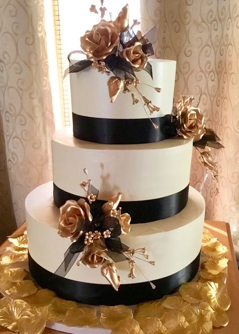 Gold, satin black, and ivory buttercream wedding cake. Wedding Cake Ideas Black White And Gold Simple, Quinceanera Cakes Black And Gold, Wedding Cakes Black And Gold, Black White And Gold Wedding Party, Gold And Black Cake Ideas, Black Gold And Cream Wedding, Black Tie Wedding Cake Ideas, Black White Gold Wedding Cake, Black White And Gold Wedding Cake