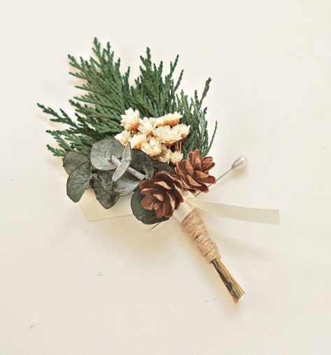 "This fragrant, natural cedar boutonniere creates a sweet and simple winter-inspired look. It features sprigs of dried natural cedar and  eucalyptus along with miniature pine cones and little groups of ivory flowers. Jute twine base with a little ivory ribbon accent tie.   DETAILS  ♥ Listing is for one boutonniere. ♥ Each measures about 4\" tall ♥ Pin included. ♥ Wrist corsage available! -- WG" Winter Wrist Corsage, Wedding Corsage Ideas, Cedar Boutonniere, Pine Boutonniere, Evergreen Boutonniere, Forest Boutonniere, Winter Wedding Groomsmen, Winter Wedding Boutonniere, Wedding Officiant Business