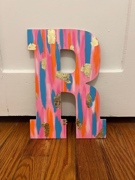 This is a colorful letter from your choice of letter with beautiful colors and cold flakes that stand out! Perfect for dorm rooms! Pink Yellow Orange Wooden Letter, Cute Wood Letter Painting Ideas, Smear Painting Canvas, Dorm Room Diy Decor, Sorority Letters Painted Wooden Pink, Painted Initial Letters, Dorm Room Paintings Canvases, Painted Sorority Letters Wooden, Sorority Letters Painted Wooden