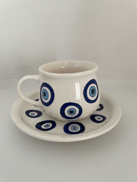 Handpainted evil-eye theme , wide cup * Evil eye cup to protect you from negative energy * best choice of coffee and tea lowers. * it's completely hand painted  * cracking images that appear under the glaze, may occur during of after firing on tile products. These are not faults. It's natural process of tile art. *None of my products are microwaveable. And the dishwasher may cause colors to fade, so it is not recommended. PLATE : diameter 15 cm CUP: diameter 8cm (approximately) P.S: as its all handmade there might me couple of color dots into the products, be aware.. Evil Eye Plate Art, Handpainted Ceramic Mug, Evil Eye Ceramics, Evil Eye Pottery, Evil Eye Plate, Evil Eye Mug, Paint Cups, Cup Painting, Eye Plate