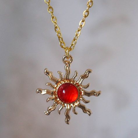 Make a statement with this pretty red sun necklace for women. This cool quirky gold plated and acrylic red sun necklace is a great way to add a nice touch to your outfit. The charm on this ladies sun necklace measures at 3cm x 2.7cm and is attached to a gold plated chain with lobster clasp. Various lengths of necklace chain are available, please select a length from the drop down menu. Please feel free to get in touch with us at Funky Earrings UK if you have any questions. We also have a wide ra Sun Clothes Aesthetic, Gold And Red Aesthetic, Red Jewelry Aesthetic, Red Aesthetic Fashion, Red And Gold Aesthetic, Red Gold Jewelry, Sun Accessories, Fire Accessories, Red Pendant Necklace