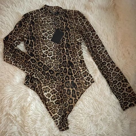 Introducing Our Purrfectly Fierce And Fashionable Leopard Print Bodysuit! This Exquisite Piece Seamlessly Blends Style And Comfort, Ensuring You Make A Bold Statement Wherever You Go. Crafted With Semi-Sheer Fabric, It Adds A Touch Of Mystery And Allure To Your Ensemble. With A Snap Bottom Closure, This Bodysuit Offers Both Convenience And A Flawless Fit. The Mock Neckline Adds A Chic And Sophisticated Touch, Elevating Your Overall Look. The Mesmerizing Animal Print Pattern Embraces Your Wild Si Leopard Print Bodysuit, Fashion Nova Bodysuit, Bustier Bodysuit, Pink Long Sleeve Blouse, Free People Bodysuit, Animal Print Pattern, Mock Neck Bodysuit, Blue Bodysuit, Animal Prints Pattern