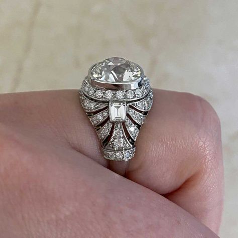 This stunning platinum ring features a 3.43 carat antique cushion cut diamond, J color and VS2 clarity. The center diamond is surrounded by a row of old European-cut diamonds. A bow design decorates the shoulders, set with old European cut diamonds and a baguette cut diamond. This ring has a low profile and is inspired by the Edwardian era. The total approximate weight of the additional diamonds is 1.10 carats. The approximate measurements of the center diamond are 10mm x 8.86mm x 7.08mm. This r Diamond Antique Rings, Ring Redesign, Antique Cushion Cut Diamond, The Edwardian Era, Interesting Fashion, Antique Cushion Cut, Estate Diamond Jewelry, Vintage Diamond Ring, Antique Cushion