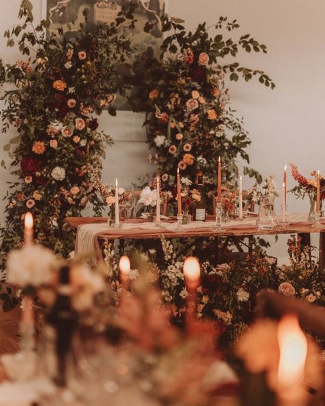 A rich autumnal palette creates for a romantic and modern wedding atmosphere 🍂💫 A canopy of lush foliage, flickering candles, and elegant blooms brought an intimate, cosy atmosphere to life, wrapping the day in timeless romance. Soft neutrals paired with rich burgundies, deep reds, soft peaches, and vibrant oranges - a seasonal colour combo that’s elegant, timeless, and utterly swoon-worthy. The pièce de résistance? The whimsical ceremony arch, beautifully repurposed as a stunning backdro... Bridgerton Fall Wedding Aesthetic, Luxury Autumn Wedding, September Wedding Colors Elegant, Warm Earth Tone Wedding, Autumn Wedding Aesthetic, Silchester Farm, Brown Wedding Flowers, Whimsical Ceremony, Auburn Wedding