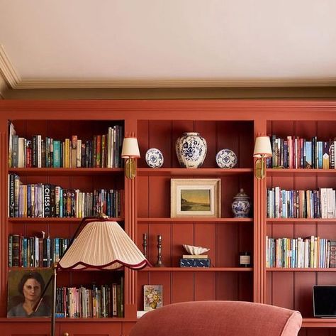 Anna Eleri on Instagram: "you can always count on @uns.hobbs_interiors to find a way to bring warmth to a space, photographed by @boz_gagovski 🧡" Red Bookshelves, Picture Gallery Red, Bookcase And Desk, Red Bookcase, Beige Shelves, Red Bookshelf, Pretty Bookshelves, Essex House, Red Shelves