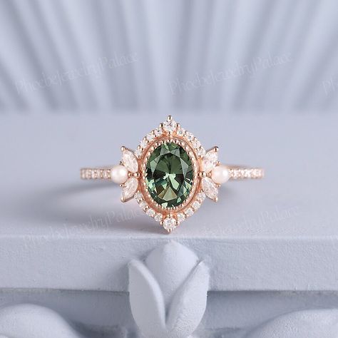 Vintage Oval Green Sapphire Pearl Engagement Ring Art Deco Filigree Solid Gold Wedding Ring Unique Birthstone Ring Anniversary Gift Handmade PRODUCT SUMMARY Metal Type: yellow, white or rose solid 14 or 18k gold. Size: All sizes are available, contact me if they do not contain the size you want in the drop-down menu. ☪☪Engagement ring ⚜Center Stone - Lab Grown Olive Green Sapphire Cut - Oval Size - 7x5mm ⚜Side Stone - Moissanite Cut - Round Weight - 0.33ct Clarity - SI-VS Color- G-H ⚜Band width - 1.8mm IMPORTANT INFORMATION  ☪Shipping ⚜It usually takes 2-3 weeks for production and 2-5 days for shipping to most US destinations. Free shipping within US. ⚜If you want to receive your ring sooner, rush order and shipping upgrade services are available. ☪Engraving You can order a custom engravin Sage Green Sapphire Engagement Ring, Vintage Green Ring, Gold And Emerald Wedding Ring, Non Traditional Wedding Rings Vintage, Art Deco Ring Engagement, Subtle Engagement Rings, Emerald Green Wedding Ring, Oval Vintage Engagement Ring, Engagement Rings Pearl