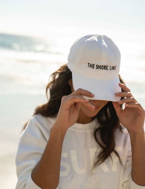 The logo baseball hat is a cotton hat that features an adjustable back strap. The embroidered THE SHORE LINE logo in contrast stitching sits at the center front. Size - one size fits most Beach Merch Photoshoot, Beach Brand Photoshoot, Photos With Hats, Women In Baseball Hats, Hat Product Photography, Hat Photoshoot Ideas, Merch Photoshoot Ideas, Hat Ads, Hat Modeling