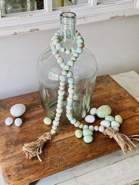 Easy Spring-time garland made with wood beads + twine DIY tassels.     #diy #craft #spring #farmhouse #woodbead #beadgarland Diy Painted Table, Diy Farmhouse Crafts, Umbrella Wreath, Diy Tassels, Craft Spring, Tassels Diy, Tissue Paper Garlands, Twine Diy, Farmhouse Beads