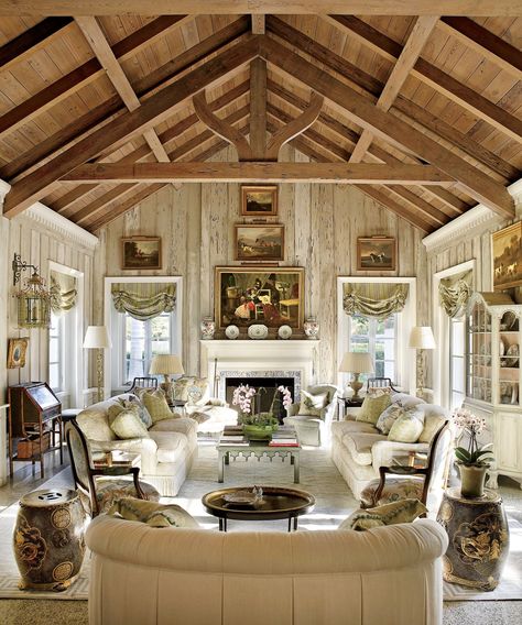 Pecky-cypress paneling in the living room of Nancy Morton’s Boca Grande, Florida, home adds a rustic feel to the vaulted room. Pecky Cypress Paneling, Wood Benches, Florida Villas, Pecky Cypress, Fireplace Tile Surround, Barn Living, White Fireplace, Exposed Beams, Fireplace Tile