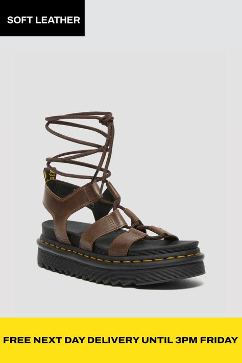 Go your own way with our gladiator inspired Nartilla sandal. Built from durable Oily Illusion leather. Statement laces add strength and our EVA platform sole keeps it light. Iconic yellow stitching and unmistakable heel loop complete the look. Ready when you are. Ankle-tie, gladiator-style sandal with 72 inch laces. New Oily Illusion is a smooth full-grain leather with a rich, waxy finish. Our SoftWair memory foam footbed ensures comfort from the first step. Built on the super-lightweight EVA sole, with a ripple tread. Our sandals run large, if you are between sizes we recommend buying a size down Upper: 100% Leather Inner: 100% Textile Sole: 100% PVC. | Dr. Martens Nartilla Illusion Leather Gladiator Sandals in Brown, Size: 7 Brown Dr Martens, Go Your Own Way, Leather Gladiator Sandals, Goodyear Welt, Gladiator Sandals, Full Grain Leather, First Step, Memory Foam, Dark Brown