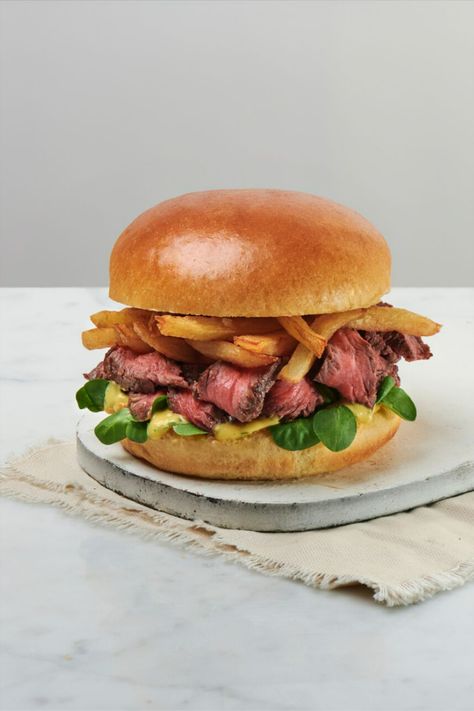 A steak burger served on a white wooden board on a white table. Steak Burger, Steak Frites Sandwich, Gourmet Beef Burgers, Burgers With Fries, Beef Burger Aesthetic, Beef Burger Photography, Restaurant Steak, Traditional French Recipes, Fillet Steak