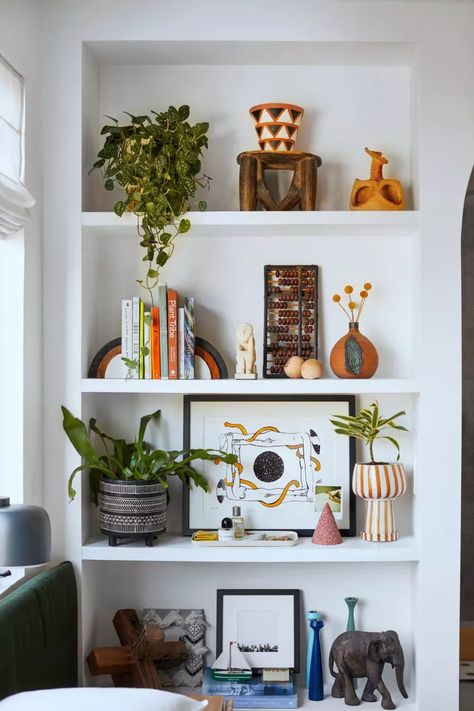 20 Travel-Inspired Decorating Ideas to Evoke Your Favorite Destination Home Decor Ideas Shelves, Floating Shelf Decor Colorful, Funky Bookshelf Styling, Bookshelf Decor Colorful, Shelf Styling Colorful, Eclectic Shelf Decor Living Room, Colorful Shelves Decor, Shelf Decor Living Room Eclectic, Shelf Decor Bedroom Colorful