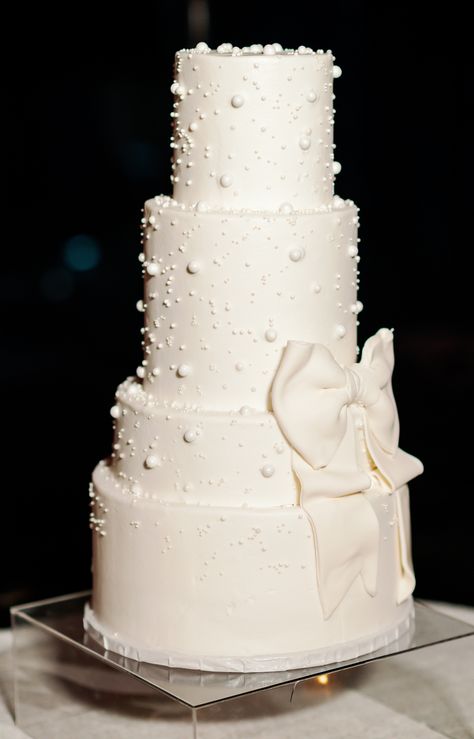 modern pearl and bow detail white wedding cake Wedding Cake Designs Pearls, White Wedding Cake With Bow, Pearl Cake Topper, Wedding Cakes With Bows, Black And Pearl Wedding, Bow Themed Wedding, Pearl Cake Wedding, Pearl Wedding Details, White Cake With Pearls