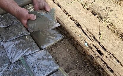 Learn how to make a concrete pathway with this easy DIY tutorial. #diy #outdoor #pathway Making A Stone Walkway, Easy Garden Paths Diy, Concrete Pebble Walkway, Cheap Walking Path Ideas, Easy Diy Pathway Walkways, Diy Concrete Bricks, Diy Rock Pathway, Cement Rocks Diy Pathway, Concrete In Bags Pathway