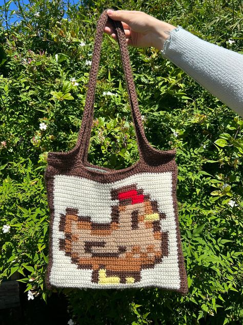 ✨Make your own crochet Stardew Valley chicken tote bag!✨ 📏 The main body of this bag is approximately 32.5cmx28cm, and the length of the handles measured from the top of the bag is approximately 31cm 📏 ✍🏼Part of this pattern includes instructions that have been written out in 3 different ways 1. Stitch Fiddle Graph  2. Colour Block Instructions  3. Written Instructions  🧶Materials needed:🧶 - 4mm crochet hook (can use other sizes at your own discretion) - Dowel rod - Scissors - Darning needl Stardew Valley Knitting Pattern, Stardew Valley Knitting, Stardew Valley Crochet Pattern Free, Crochet South Park, Stardew Valley Crochet Pattern, Crochet Stardew Valley, Stardew Valley Crochet, Crochet Pouch Pattern, Stardew Valley Chicken