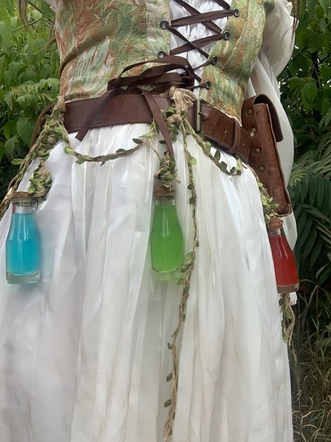 Green corset over white dress with hanging potions Medieval Fair Costume, Ren Faire Fairy Accessories, Ren Faire Outfits Accessories, Ren Fair Elf Costume, Fae Ren Faire, Trinket Fairy Costume, Ren Faire Goblin, Fantasy Apothecary Outfit, Forest Elf Aesthetic Outfit