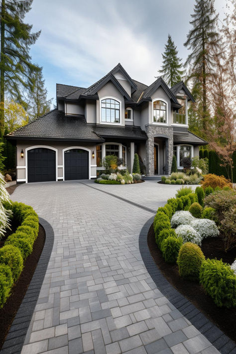 Elegant driveway landscaping with grey paving and lush greenery leading to a grand two-story home with dark roofing. Driveway Pavers Design, Front Garden Ideas Driveway, Beautiful Houses Exterior, Garden Ideas Driveway, Beautiful Driveways, Driveway Entrance Landscaping, Modern Driveway, Brick Driveway, Stone Driveway