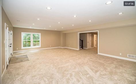 Large basement room with windows, beige walls, white trim, can lights, beige carpet Light Beige Carpet Living Room, Wall Color For Beige Carpet, Beige Walls White Trim, Beige Basement, Beige Carpet Living Room, Beige Carpet Bedroom, Downstairs Ideas, Basement Floors, Basement Staircase