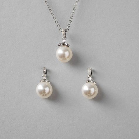 Simple yet alluring pearl earrings and necklace set. A single pearl hangs from a micro CZ accented drop for a little sparkle to your style. They are both about .75 inches long with a 10mm pearl and the necklace is 16 inches with a 2-inch extender. Available in rhodium or gold plate, they are lead, nickel, and cadmium-free. #bridesmaidgifts #weddinginspiration #weddingnecklaceset #bridalnecklace #bridalnecklaces #bridalnecklaceset #pearlpendant #pearlpendants Bridesmaid Jewelry Earrings, Pearl Earrings And Necklace, Pearl Jewelry Set, Wedding Necklace Set, Earrings And Necklace Set, Single Pearl, Bridal Necklace Set, Pearl Jewelry Sets, Earrings And Necklace