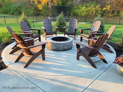 Patio Ideas For Mobile Home, Backyard Round Fire Pit Ideas, Adirondack Chairs Around Fire Pit, Concrete Patio Fire Pit Ideas, Fire Pit On Concrete Patio, Concrete Patio Ideas With Fire Pit, Furniture Around Fire Pit, Outdoor Fire Pit Area Ideas, Round Concrete Patio