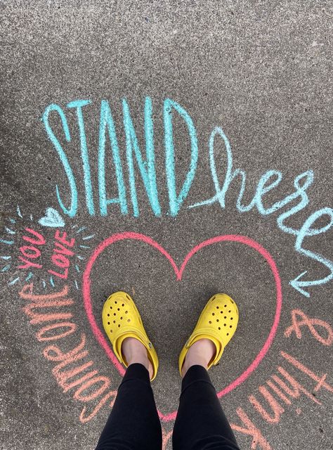 Stand here and think about someone you love. Yellow crocs. Interactive Chalkboard Ideas, Interactive Sidewalk Chalk Art, Encouraging Chalk Art, Chalk Art Positive Messages, Kindness Chalk Art, Positive Chalk Messages, Mental Health Chalk Ideas, Inspiring Chalk Art, Chalk Messages