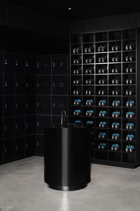 Designed to be calm and soothing, the Ivy Studio, a boutique fitness chain in Downtown Montreal, is primarily used for yoga and pilates classes. Instead of bright white interiors, Architect Philip Staszewski opted for a darker palette, using different materials like a glossy laminate on the locker doors and a stained oak wood wall veneer to play with contrast. #YogaStudio #DarkInteriors #InteriorDesign Gender Neutral Bathrooms, Boutique Gym, Cycling Studio, Boutique Fitness, Spin Studio, Mario Botta, Fitness Boutique, Concrete Column, Water Station