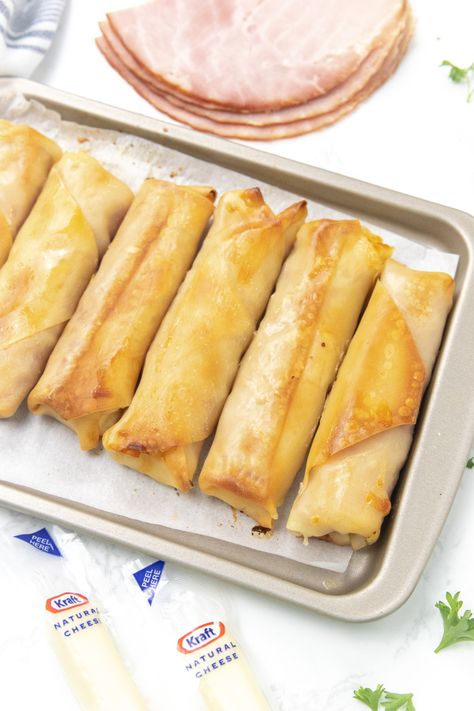 Ham and Mozzarella Cheese Sticks are a tasty and cheesy snack or appetizer. Ham and cheese stuffed inside a baked egg roll! #passion4savings #baked #oven #ham #cheese #eggrollwrapper #easy #quick #partyfood #appetizer #snack #schoolsnack Ham And Cheese Egg Roll Wrappers, Ham Egg And Cheese Roll Ups, Ham And Mozzarella Cheese Sticks, Ham And Cheese Egg Rolls, Ham And Cheese Sticks, Oven Ham, Ham Cheese Rolls, Mozzarella Appetizers, Ham And Cheese Roll Ups