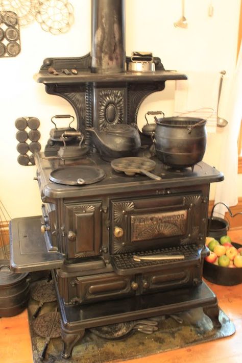 This is an old-fashioned wood burning cooking stove with all of the bells and whistles.  Notice all if the pots, kettles, and irons.  You can also see a type of frying pan and muffin pan on the front left and middle burners Alter Herd, Antique Wood Stove, Wood Burning Cook Stove, Old Stove, Wood Stove Cooking, Vintage Stoves, Antique Stove, Cast Iron Stove, Vintage Appliances