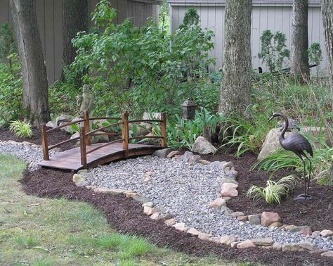 I love the idea of a rock creek bed winding along the back edge of the garden. The footbridge lends a Zen element to the design. Lodge Style Landscaping, Dry Retention Pond Landscaping, Dry Pond Ideas, Small Backyard Bridge Ideas, Backyard Bridges Dry Creek, Bridge Over Dry Creek Bed, Drycreek Landscaping, Dry Pond, Arched Bridge