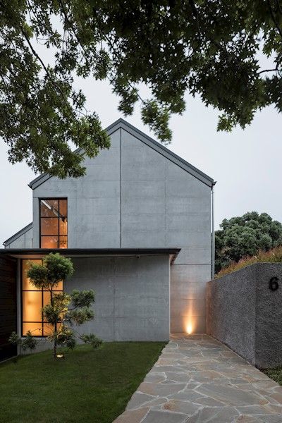 Vernacular barn forms have come to town in this double gable house – an exhibition of precision in concrete and steel. Expertly handled natural light across precast and in-situ concrete creates a warm and bold interior. Intense attention to European-influenced detailing has created a controlled and defined home of very high quality. Clever planning has reduced the large kitchen and scullery areas typical of houses of this type, ensuring an appropriate scale is maintained. Concrete Homes Exterior, Kitchen And Scullery, Bold Interior, Gable House, House Cladding, Concrete Houses, Retreat House, Modern Barn House, Concrete Home