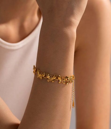 Elevate your style with our Golden Butterfly Garden Bracelet. This exquisite piece is crafted from high-quality stainless steel and features a stunning array of intricately detailed butterflies. Whether dressing up for a special occasion or adding a touch of sophistication to your everyday look. This bracelet is both durable and hypoallergenic, ensuring it remains a cherished part of your collection for years to come. Butterfly Charm Bracelet, Shape Geometric, People Women, Butterfly Bracelet, Gold Bracelet For Women, The Embrace, Stackable Bracelets, Dainty Bracelets, Butterfly Charm