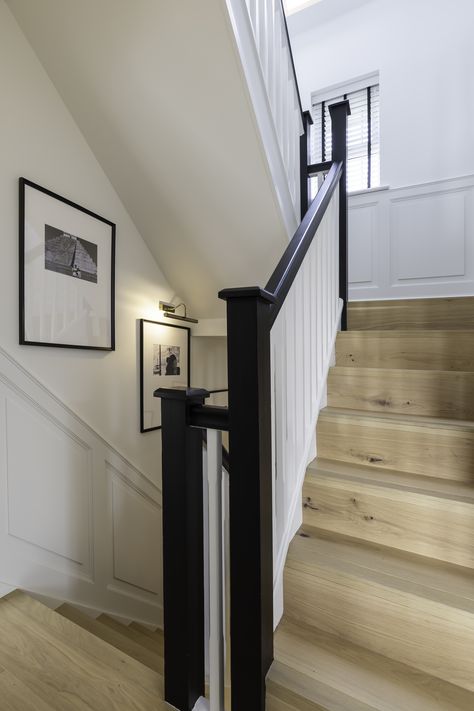 Oak wood stairs with white handrail and endposts. Oversized black frames with off centred mounts and black and white imagery tie the spaces together. Photography: Leigh Dawney Photography / www.leighdawneyphotography.com Dark Handrail Stairs, Black Frames Staircase, Black Hand Rails Stairs, Stairs With Black Handrail, Black Stair Handrail, Black Handrails For Stairs, Hallway Styling, Black Handrail, Stairs And Hallway Ideas