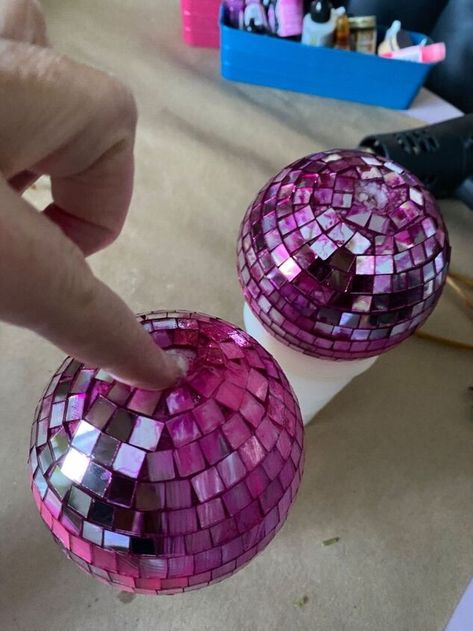 When I saw Disco Ball Cherries come across my feed, I knew a new DIY project was in my future. I ended up googling them and when I saw that some are $150, well, that sealed the deal. It wasn’t smooth sailing the whole way through but I am really pleased with how they turned out. I started with some disco ball ornaments. I decided the vine of this garland would work perfect as my cherry stems. Since they are ornaments they have a very convenient hook for drying. Over the holiday… Disco Ball Ornaments Diy, Diy Painted Disco Ball, Make Your Own Disco Ball, Diy Cherry Disco Ball, Disco Ball Craft, Disco Ball Made Out Of Cds, Ornament Garland Diy, Mini Disco Ball Chandelier, Diy Disco Ball