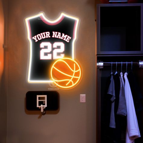 This basketball jersey neon light is the perfect choice for fans and interior decoration enthusiasts. It combines basketball elements with modern neon light technology, adding a touch of energy and dynamism to your space. The neon light is made of high-quality LED tubes, featuring high brightness and low energy consumption, ensuring a bright and soft glow in any environment. The lamp body is made of sturdy and durable materials, guaranteeing a long service life. The light comes in vibrant colors, including classic basketball orange, cool blue, and passionate red, catering to different decoration needs. It is easy to install, supporting both wall hooks and hanging methods, making it adaptable to various installation environments. Whether as a gift for basketball lovers or as an addition to Basketball Room Ideas For Boys, Room Decor Basketball, Basketball Theme Room, Basketball Room Decor, Basketball Wall Decor, Basketball Bedroom, Sports Room Decor, Basketball Shop, Basketball Room