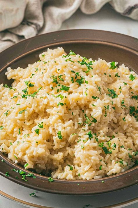 Make this delicious garlic butter rice with parmesan cheese, milk, and chicken broth. It's a flavorful rice side dish that's easy to make and will elevate your dinner! This creamy rice recipe is going to be your new favorite rice side dish recipe. Parmesan Rice Creamy, Rice For Fish Side Dishes, Garlic Butter Rice Recipes, Cheese Rice Recipe, Flavorful Rice Recipes, Easy Rice Recipes Vegetarian, Creamy Garlic Parmesan Rice, Rice Variations, Rice Dressing Recipe