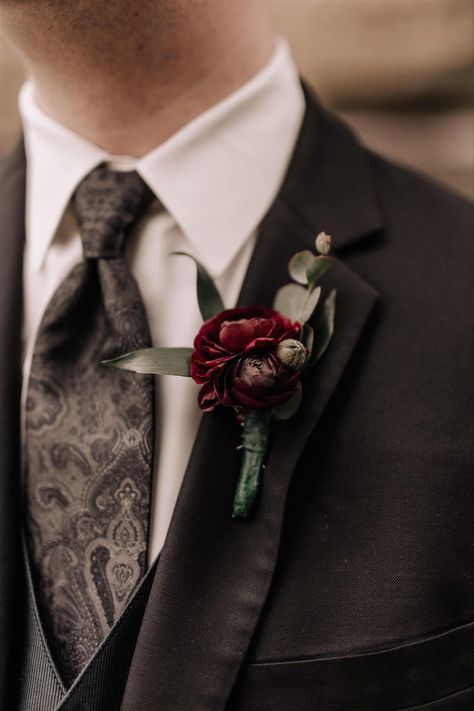 A dark burgundy boutonnière for the groom gave a touch of color to his black suit on his wedding day. To see more florals from their wedding day, click link to go to their wedding day blog post. Fall Boutonniere Burgundy, Dark And Moody Wedding Boutonniere, Dark Wedding Boutonniere, Black And Red Groom Suit, Dark Red Bouquet Wedding, Dark Boutonniere, Groomsman Flowers, Moody Boutonniere, Dark Burgundy Wedding