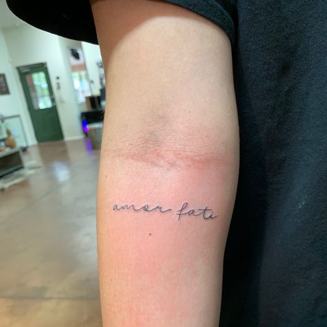 Amor fati tattoo small on inner arm Tattoo Ideas Amor, Amor Fati Meaning, Amour Fati Tattoo, Amor Fati Tattoo Fonts, Amore Tattoo Fonts, Amor Fati Tattoo Design, Fate Tattoo Ideas, Small Writing Tattoo, Small Writing Tattoos