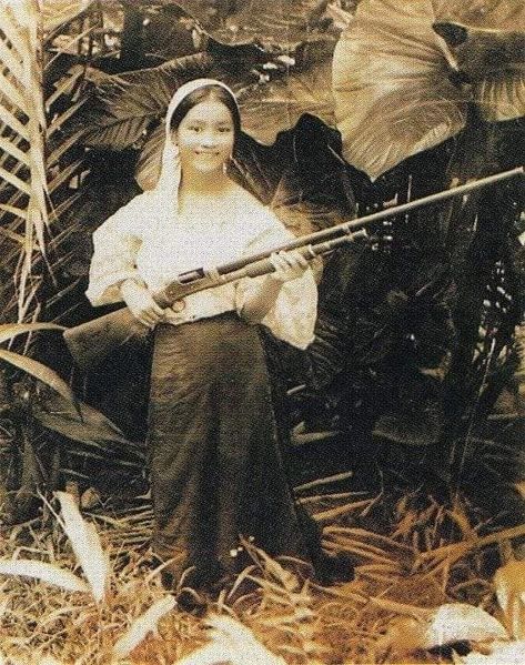 Filipina Annunciacion Chica posing for a picture as she holds a long firearm. May 23, 1915; Batangas, Philippines Old Filipino Photos, Filipino Reference Photo, Filipino History Aesthetic, Filipino School Aesthetic, Philippine History Art, Old Philippines Aesthetic, Philippines Aesthetic Vintage, Filipino Culture Aesthetic, History Philippines