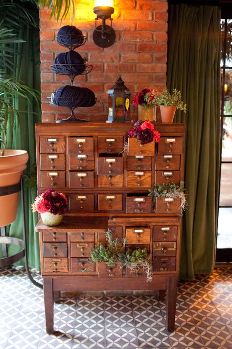 vintage library card catalogue used as escort card display.  some drawers are filled with fresh herb plantings while others have dahlia arrangements in coral, peach and burgundy. (photo courtesy of Kathi Littwin Photography - www.kathilittwin.com) Herb Drawer, Library Plants Aesthetic, Dahlia Arrangements, Apothecary Table, Apothecary Drawers, Vintage Library Card, Apothecary Chest, Library Card Catalog, Awesome Furniture